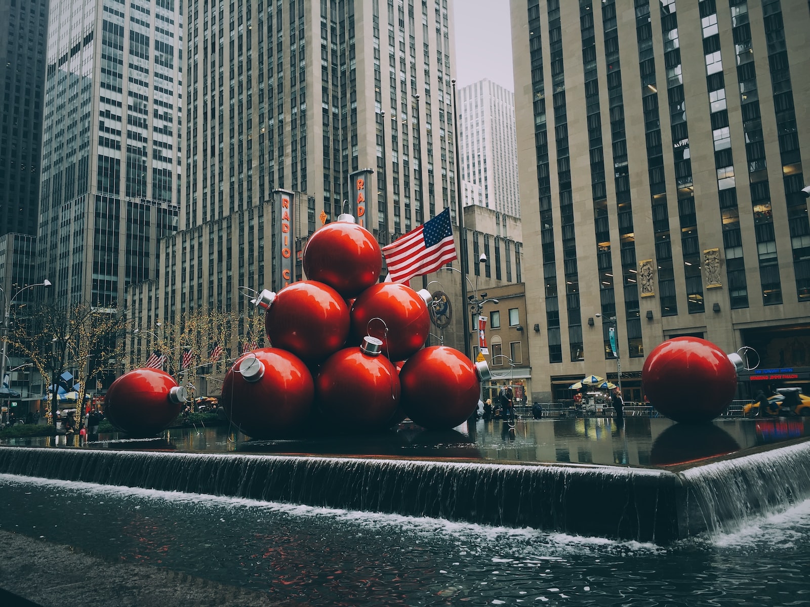 Photo by Jon Tyson red bauble fountain near buildings