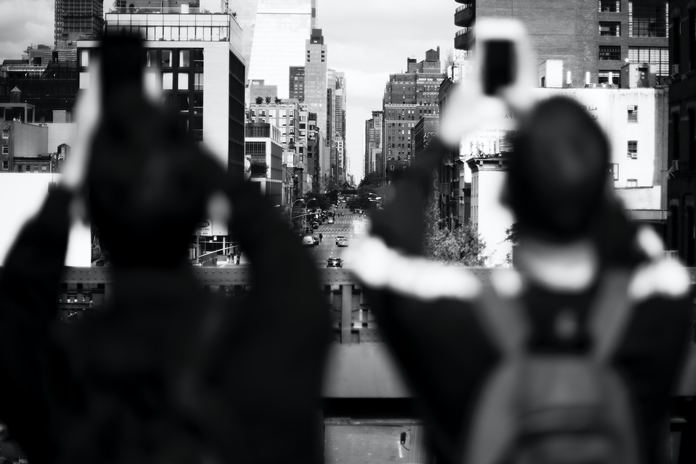 Photo by Anton grayscale shot of two persons taking photo of buildings