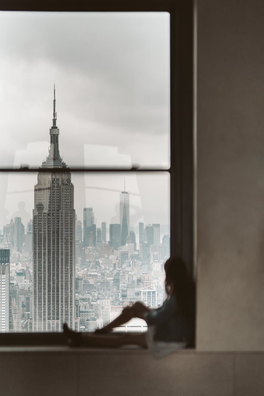 Unveiling the Enigma: Debunking Myths About New York City 1 woman sitting at window sill looking out the window at new york city