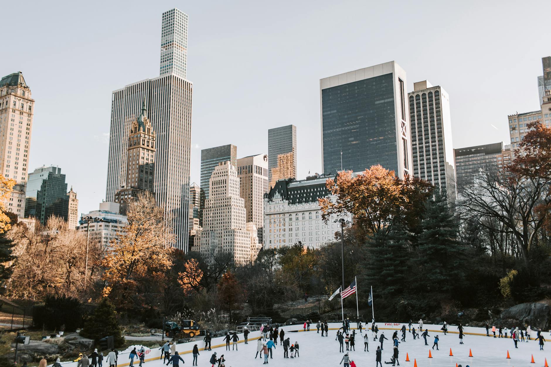 Enjoy Winter in New York City Without Breaking the Bank 4 people ice skating in the park near high rise buildings