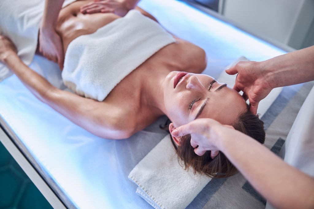 Things to do in New York in January to decompress from the festive December 5 Beautiful Caucasian female enjoying spa day while relaxing in the spa center
