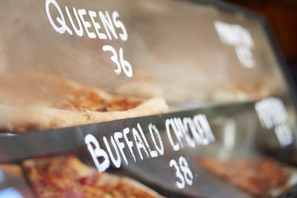Shop display, pizza and fast food price, service and take away restaurant with closeup, storefront