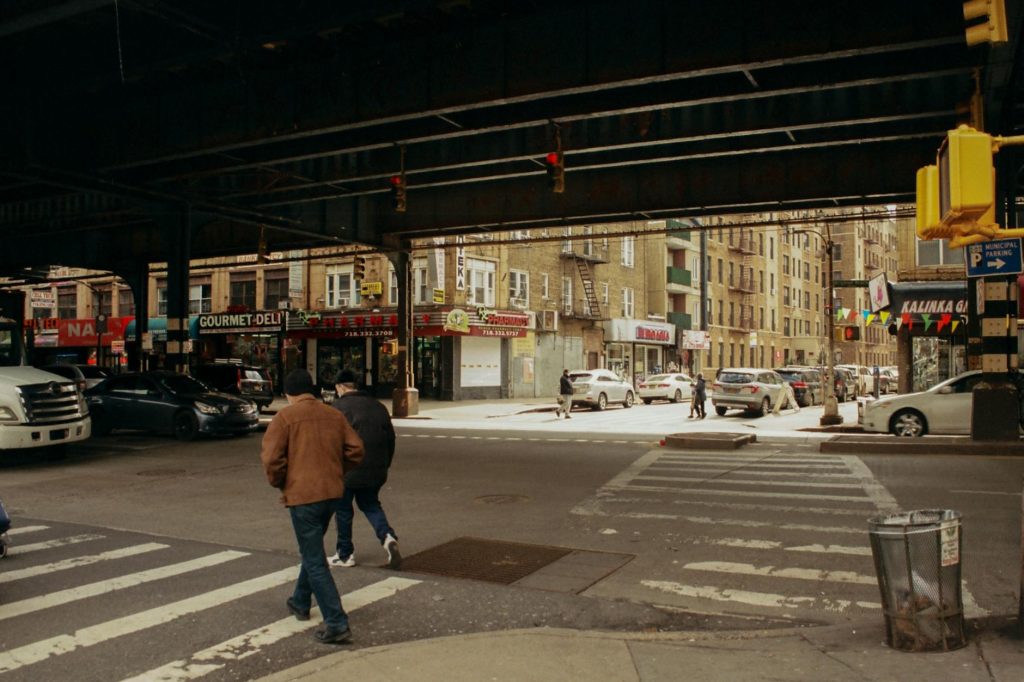 The Sidewalk Symphony: How Outdoor Dining Reimagined the Soul of New York City 2 men crossing street in a city